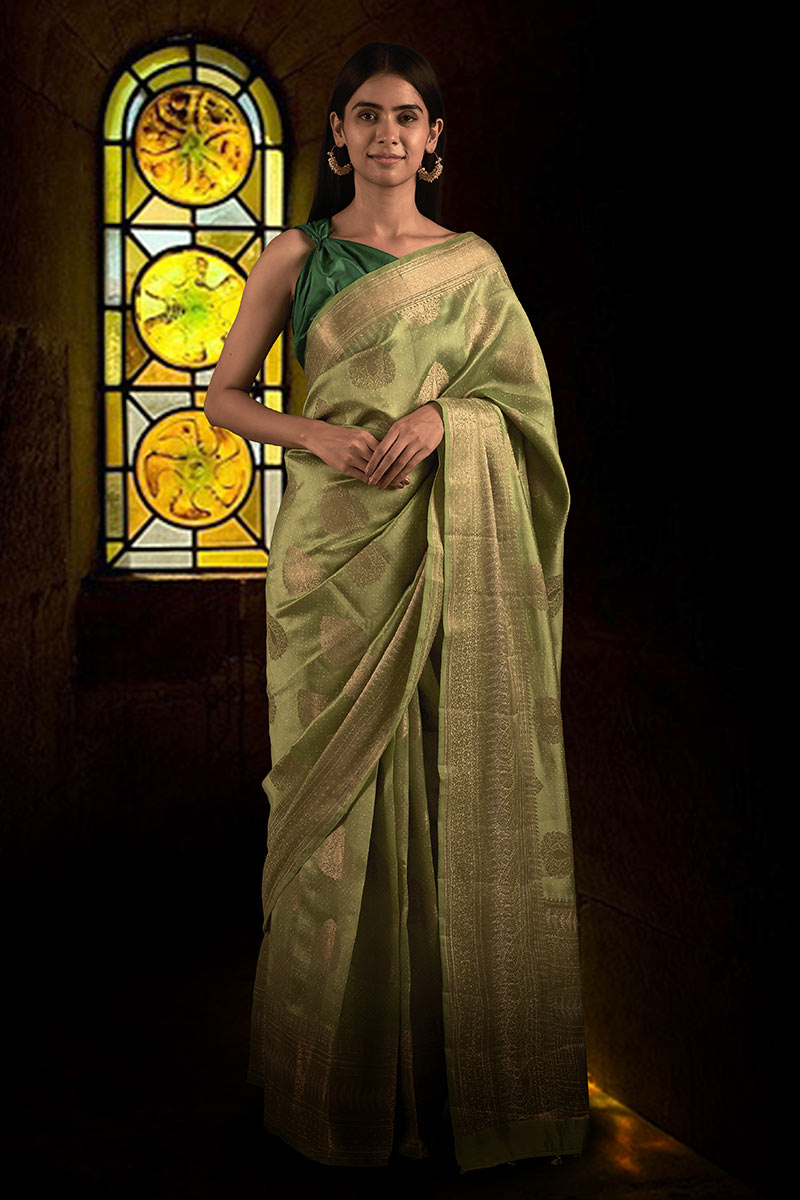 Woman in a green saree with a teal blouse posing for Chinaya