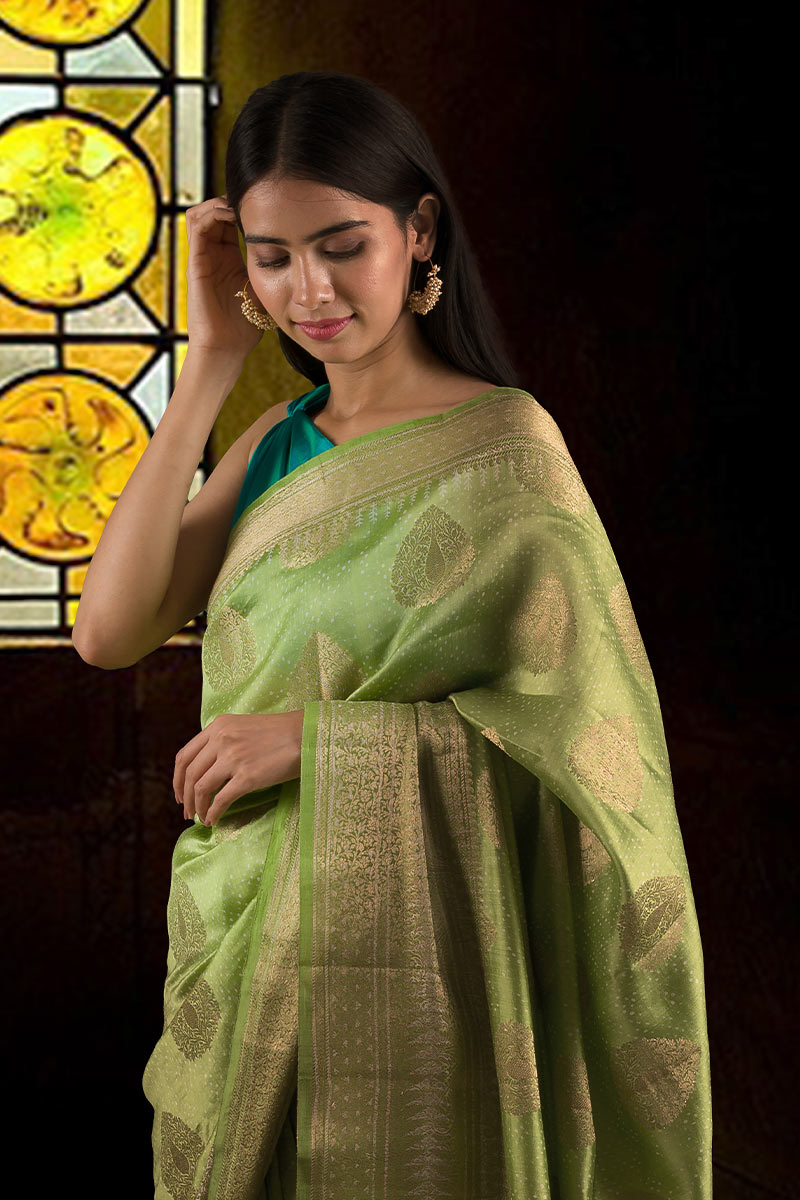 Woman in a green saree with a teal blouse posing for Chinaya